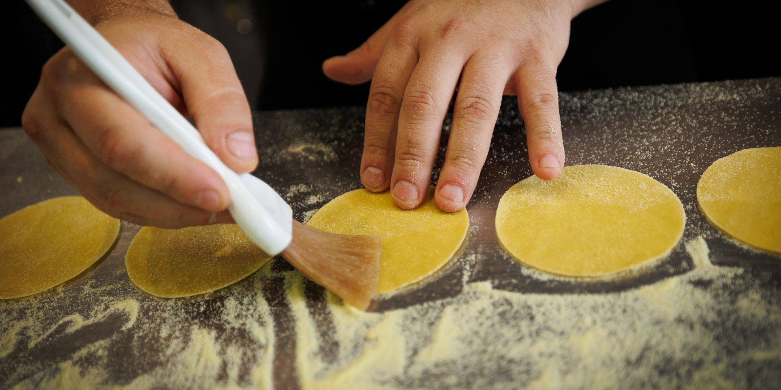 Chef preparing food on a stainless counter top.